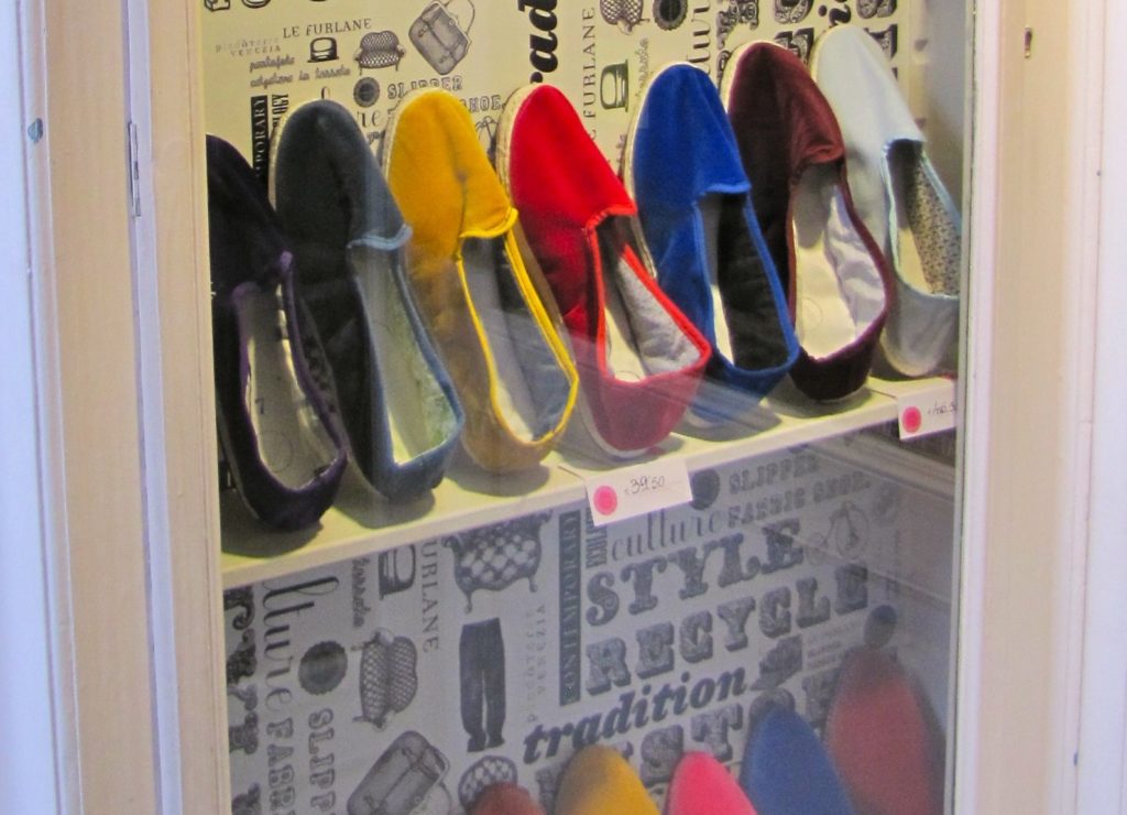 Venice with teens: brightly coloured slippers, used by gondoliers, in shop window display. Copyright©2015 reserved to photographer. Contact mapandfamily.com