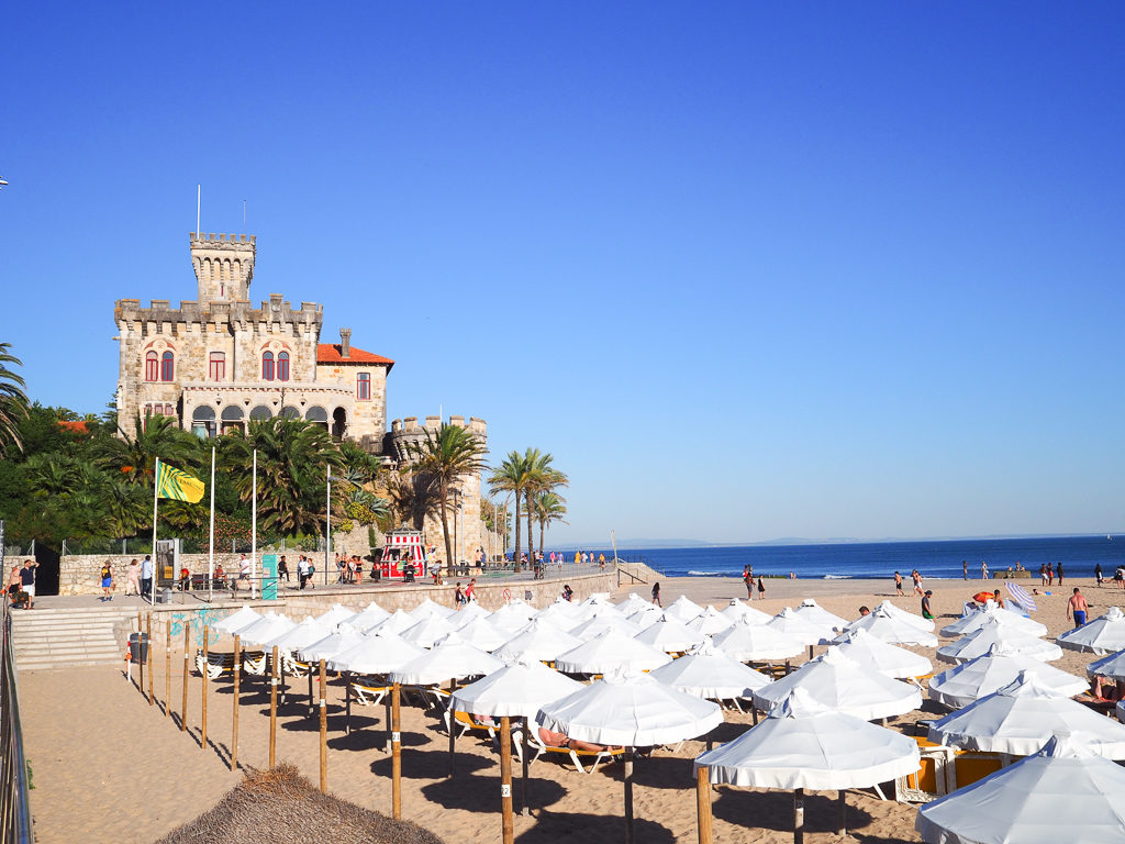 The promenade above Tamariz beach in Estoril with beach umbrellas and villa overlooking sea. Copyright ©2019 mapandfamily.com