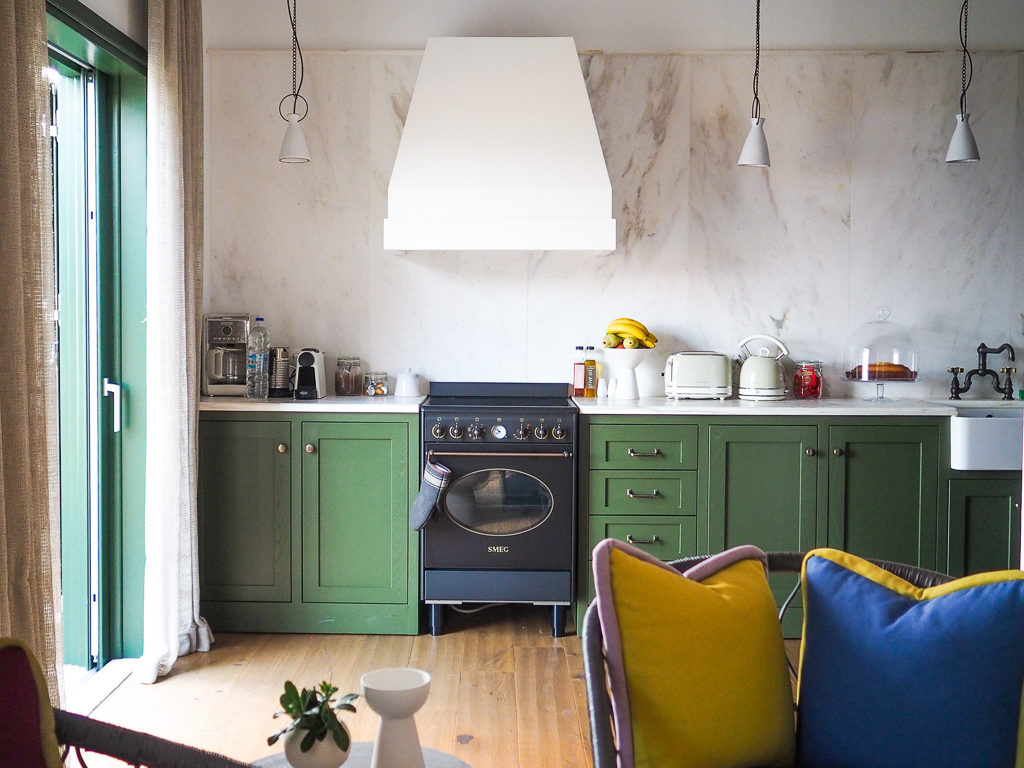 Luxury villas in Kefalonia. Kitchen area of the villa with green cupboards and marble splashback. Copyright ©2020 mapandfamily.com