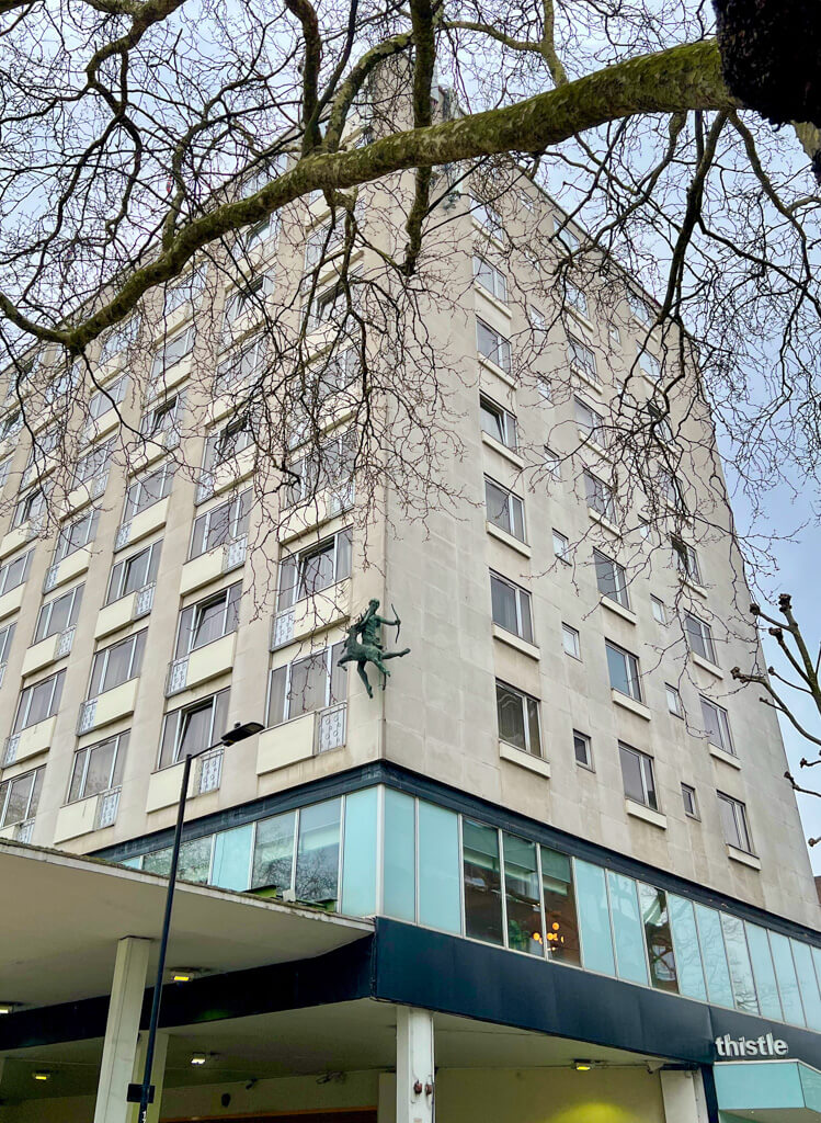A modern hotel block with a sculpted figure on the corner. Copyright@2025NancyRoberts