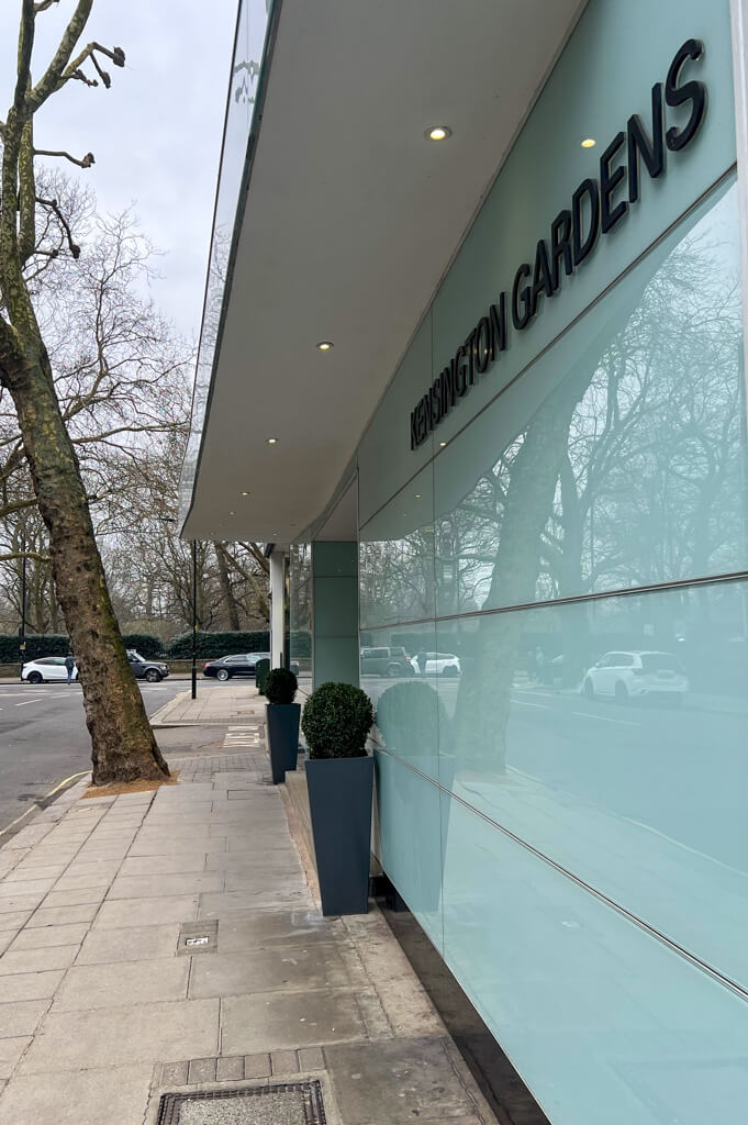 Modern glass facade of entrance to Thistle Hyde Park hotel with view to Hyde Park across the road. Copyright@2025NancyRoberts