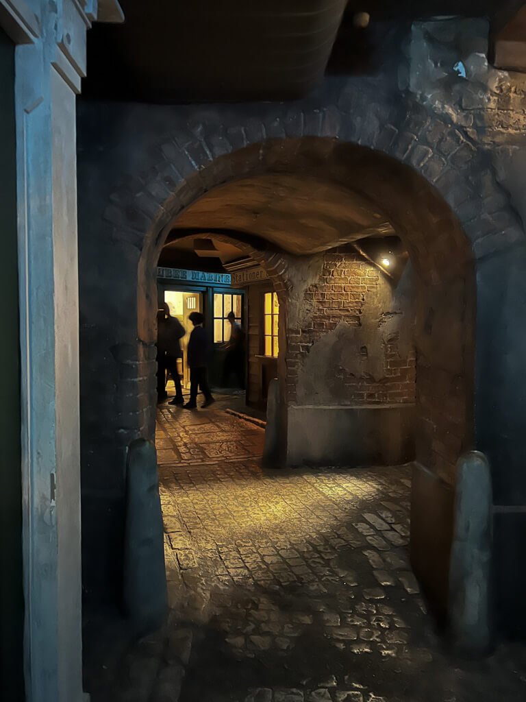 A recreated old street of cobblestones and brightly lit shop windows. Copyright@2025NancyRoberts